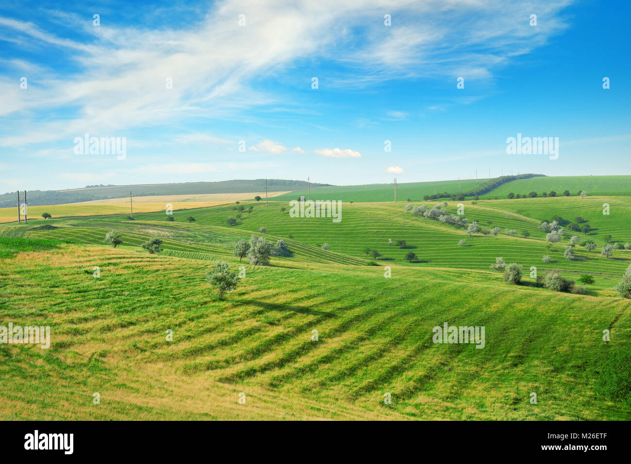 Hügeliges Gelände mit Terrasse und blauer Himmel mit weißen Wolken. Stockfoto