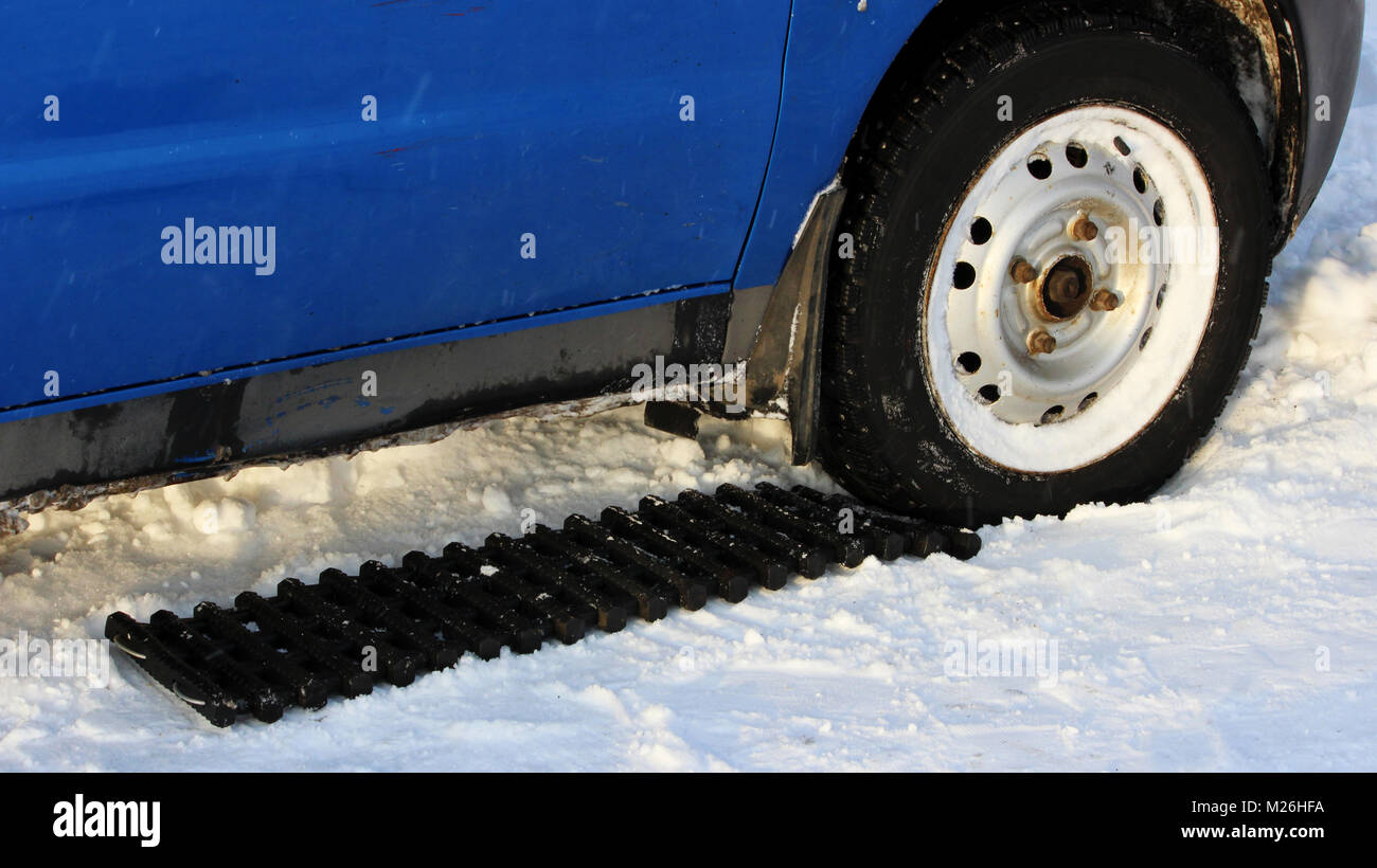 Schwarz Anti-Rutsch-Matte von einer rechteckigen Form befindet sich unter  dem Lenkrad eines low-nivellierten Auto, nachdem es in einer  schneeverwehung festsitzt, und rutscht Stockfotografie - Alamy