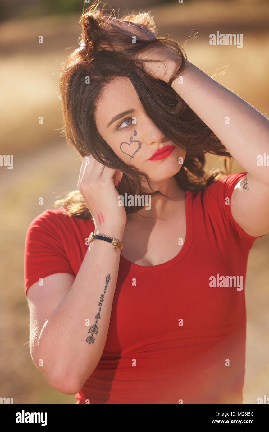 Schöne brünette Mädchen - Kopf und Schultern trägt ein rotes T-Shirt und auf dem Land. Stockfoto