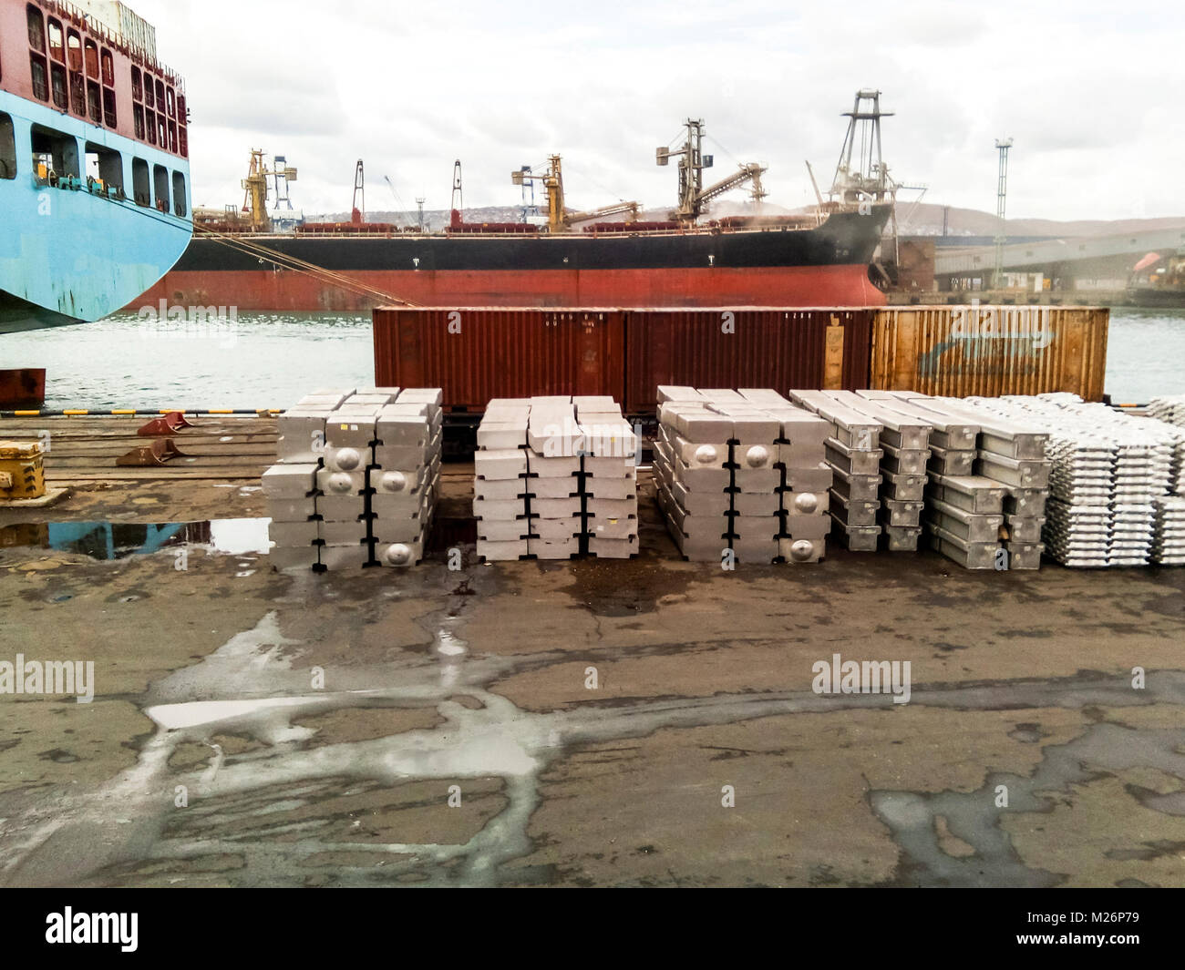 Metallstäbe auf dem Port site für den Export gefaltet. Vorübergehende Lagerung im Hafen von Rohstoffen. Port Cargo und Kräne. Stockfoto