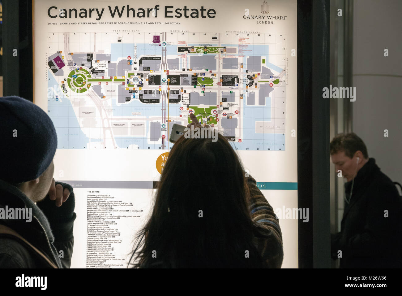 London, Großbritannien - 25 Juni, 2017 - Touristen die Prüfung eines hintergrundbeleuchteten Stadtplan in Canary Wharf Stockfoto