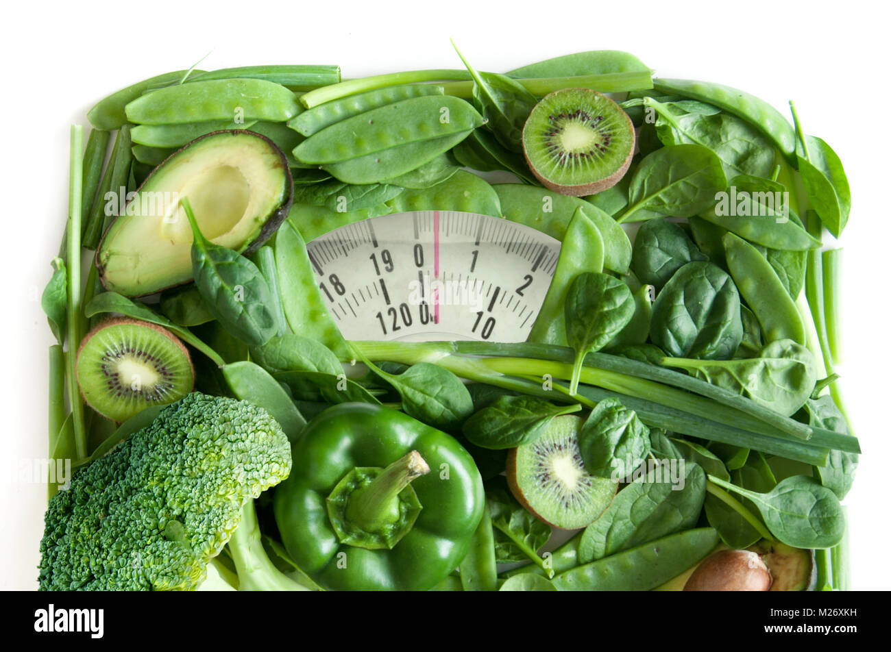 Grüne Früchte und Gemüse in Form von Bad Waagen über einem weißen Hintergrund Stockfoto