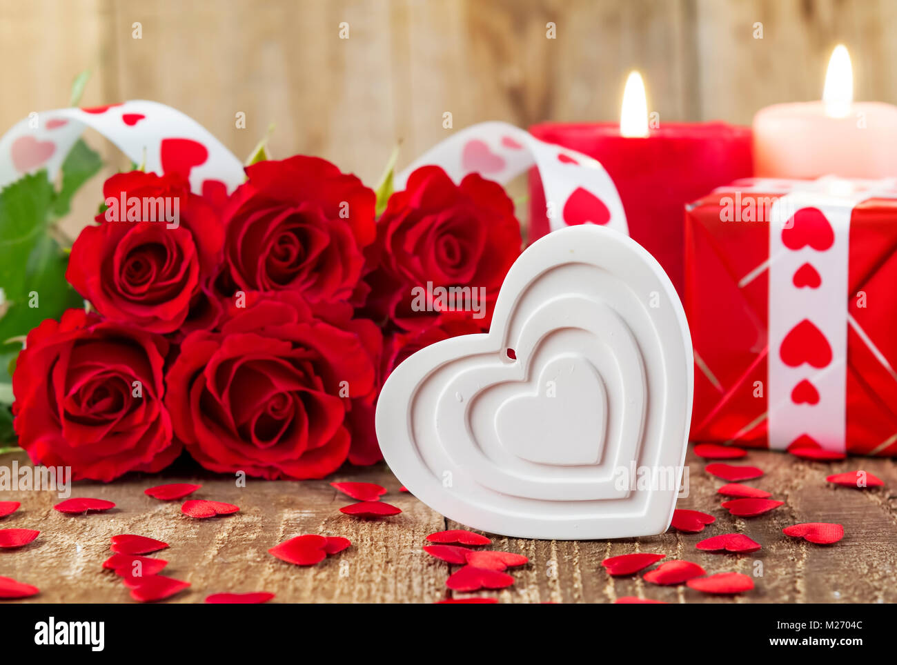 Form des weißen Herzen vor Strauß roter Rosen und Kerzen auf Holz- Hintergrund. Valentines Tag Konzept. Mutter € ™ s Tag Konzept! Fokus auf Herz Stockfoto