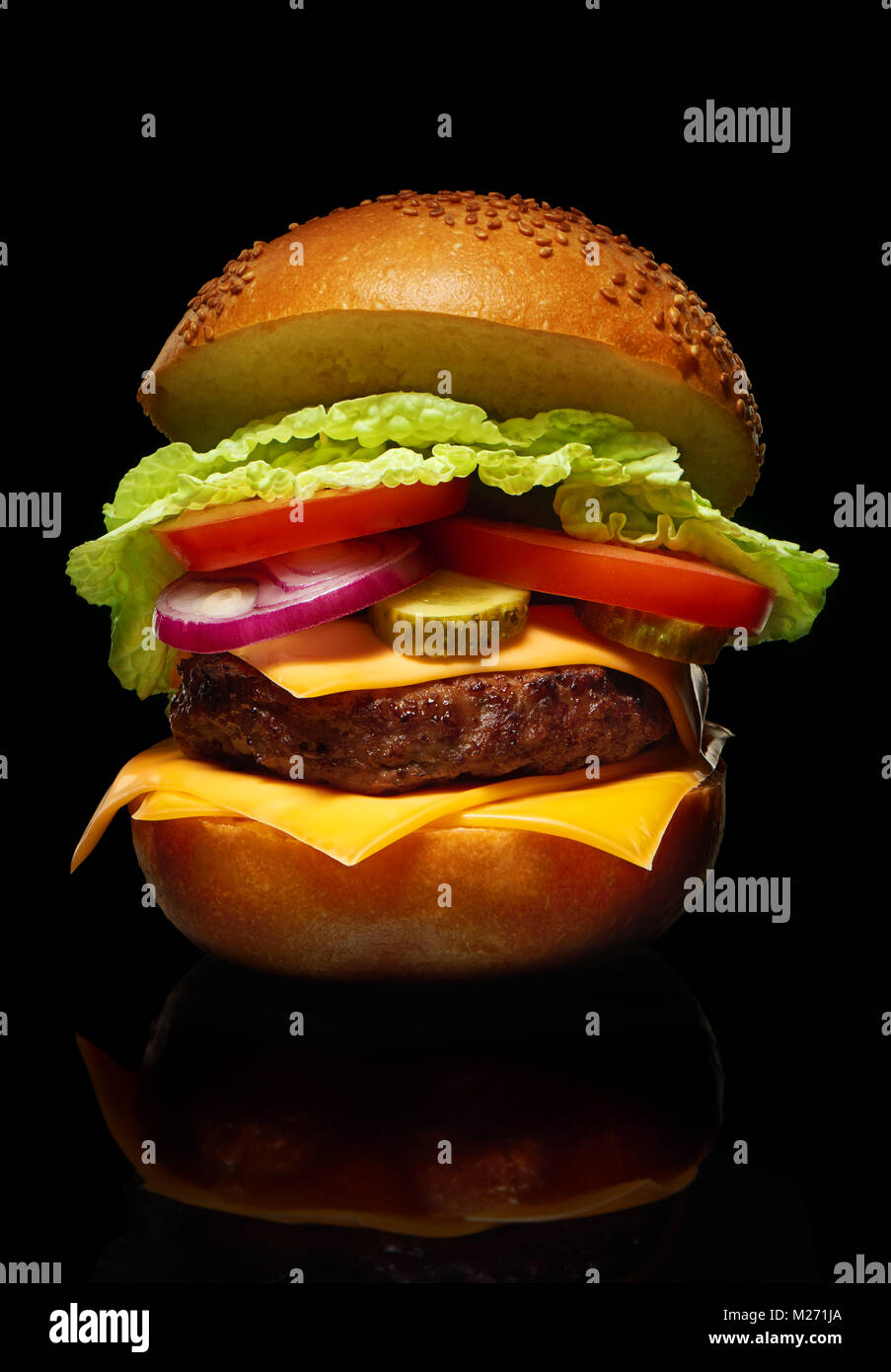 Lecker Hamburger mit Käse, Gurken, Tomaten, Zwiebeln und Salat auf schwarzen Hintergrund mit Reflektion Stockfoto