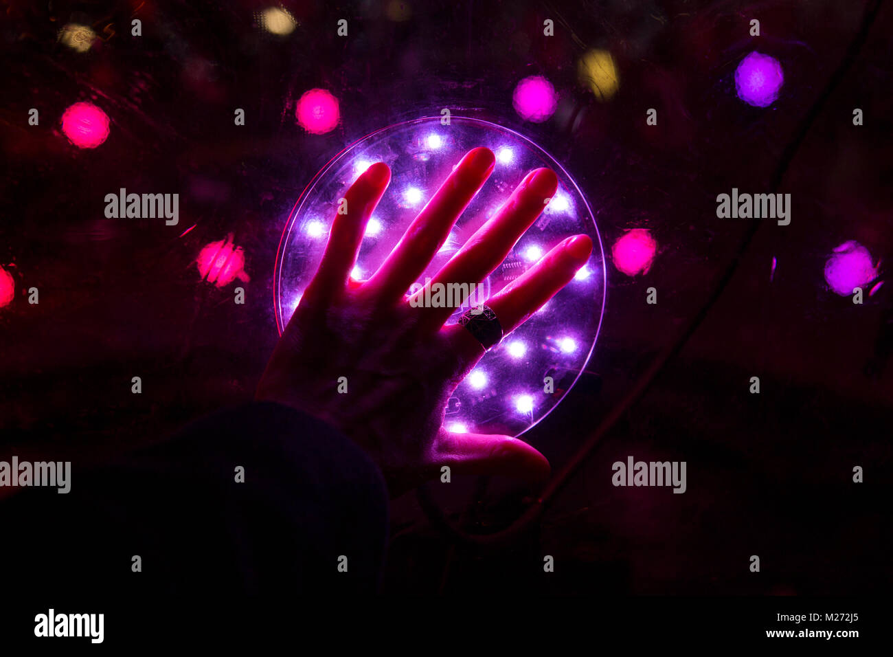 Hand berühren einen Kreis des Lichtes - Sonic, leichte Noppen Winter durch ENESS im Winter Lights Festival in Canary Wharf, London, Großbritannien Stockfoto