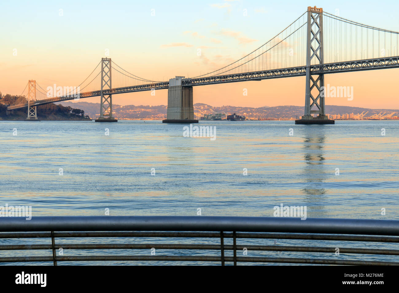 San Francisco Bay Bridge und Pier 14 Schienen bei Sonnenuntergang. Stockfoto