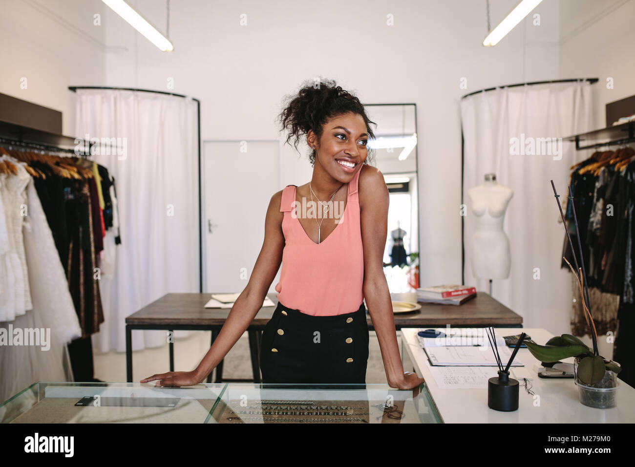 Weibliche Mode Designer stehen an ihrem Schreibtisch in Ihrer Boutique. Weibliche kleid designer in ihr Tuch Shop. Stockfoto