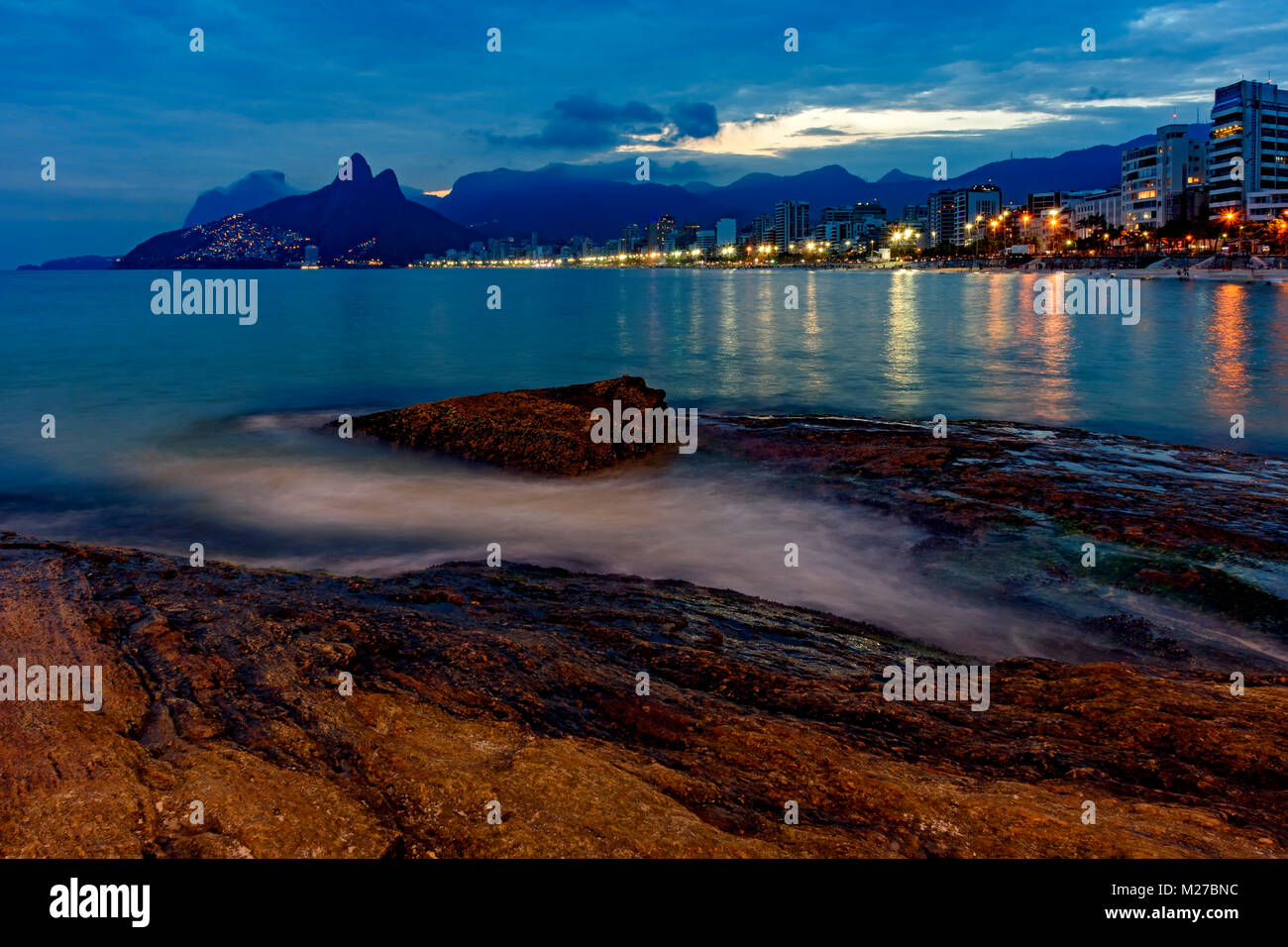 Dämmerung in Rio de Janeiro von Arpoador Stein gesehen am Strand von Ipanema mit seinen Gebäuden und Umrisse und Zwei-zimmer Brüder Hügel und die Lichter des Vi. Stockfoto