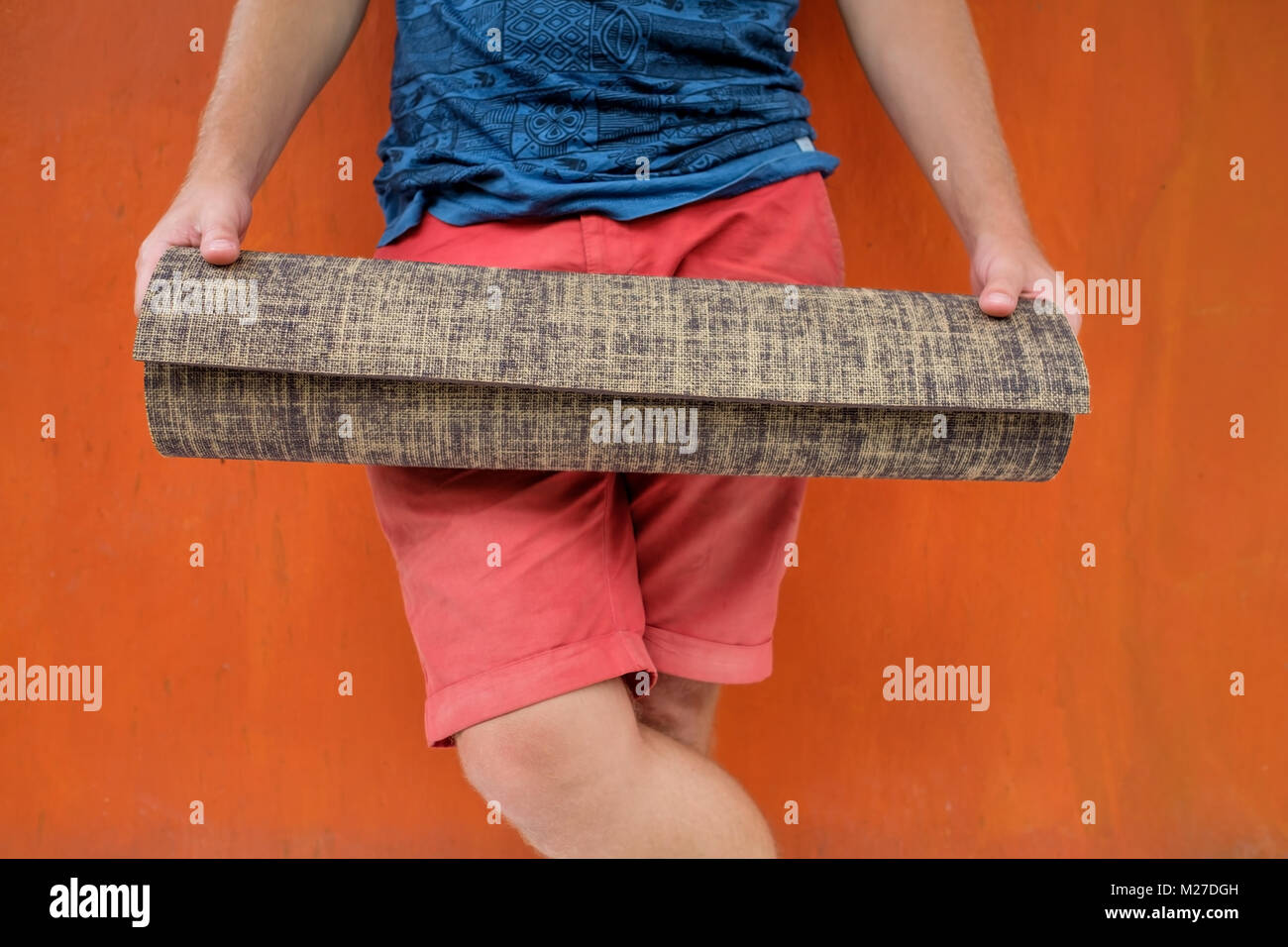 Zugeschnittenes Bild der kaukasischen Mann, Yoga Matte gerollt. Stockfoto