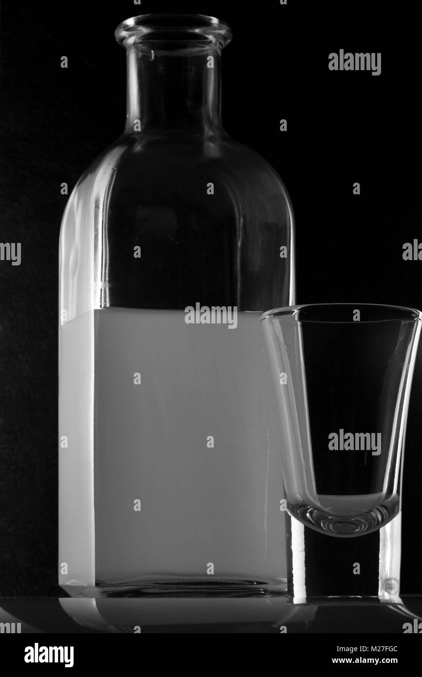 Bank von MOONSHINE und ein Glas auf schwarzem Hintergrund Stockfoto