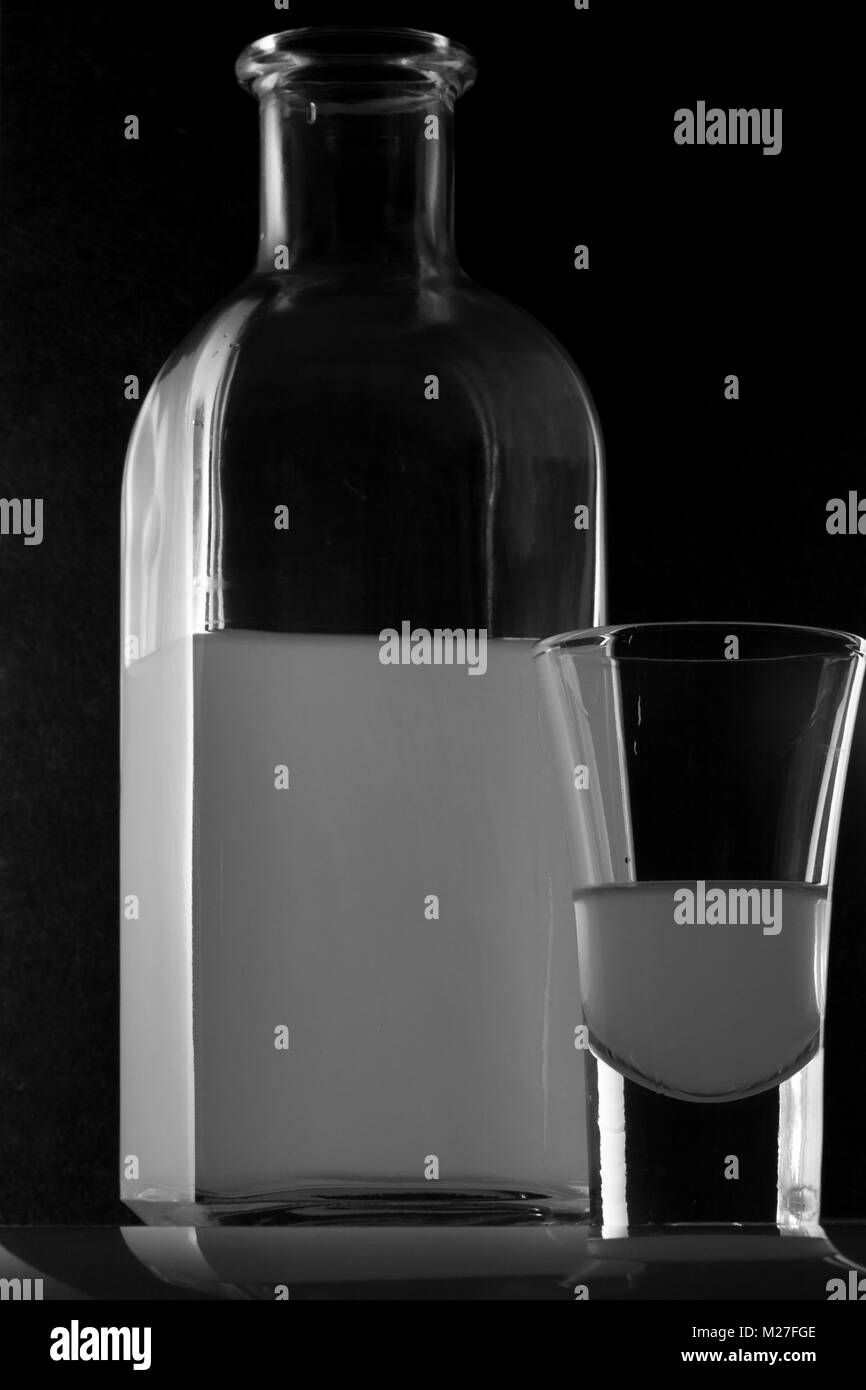 Bank von MOONSHINE und ein Glas auf schwarzem Hintergrund Stockfoto