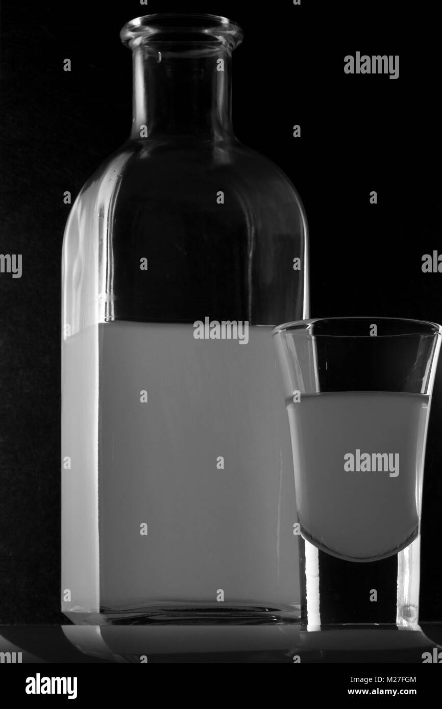 Bank von MOONSHINE und ein Glas auf schwarzem Hintergrund Stockfoto