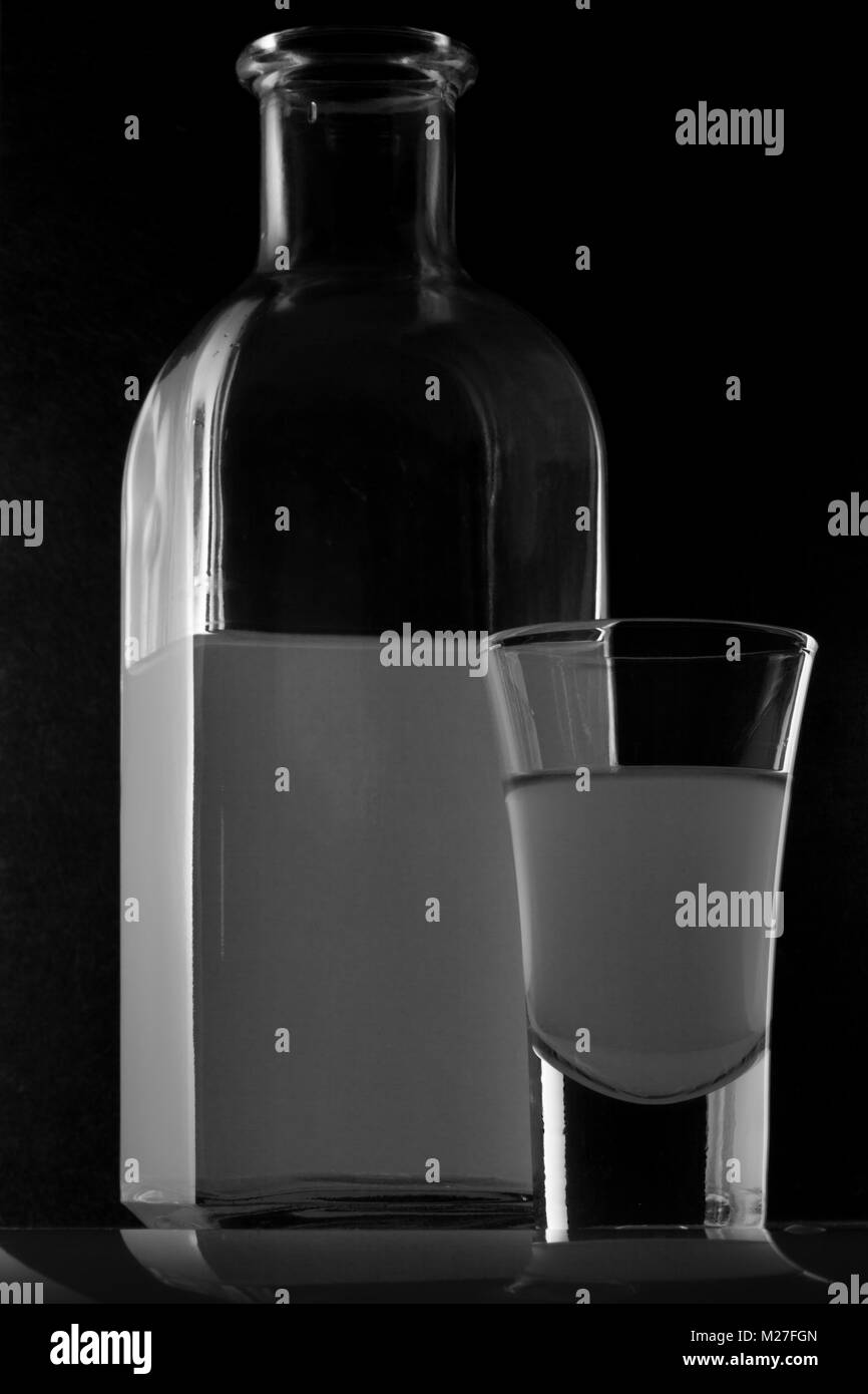 Bank von MOONSHINE und ein Glas auf schwarzem Hintergrund Stockfoto