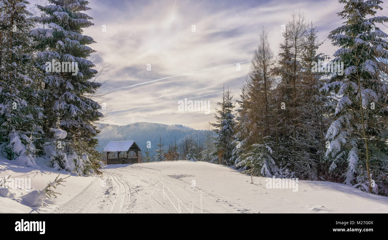 Gartenlaube aus Holz in der Nähe von Mountain Trail. Winter sonniger Tag und dunstige Berge im Hintergrund. Kremnica Berge, Slowakei, Europa. Stockfoto