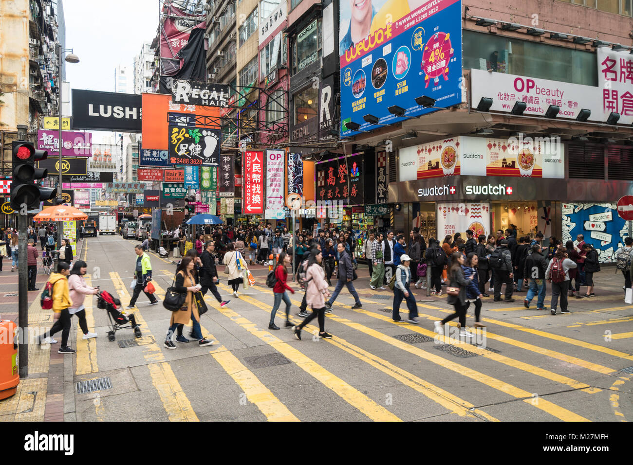 Hongkong - 25. Januar 2018: Überqueren einer viel befahrenen Straße in den sehr überfüllten Mong Kok Einkaufszentrum von Kowloon, Hong Kong Stockfoto