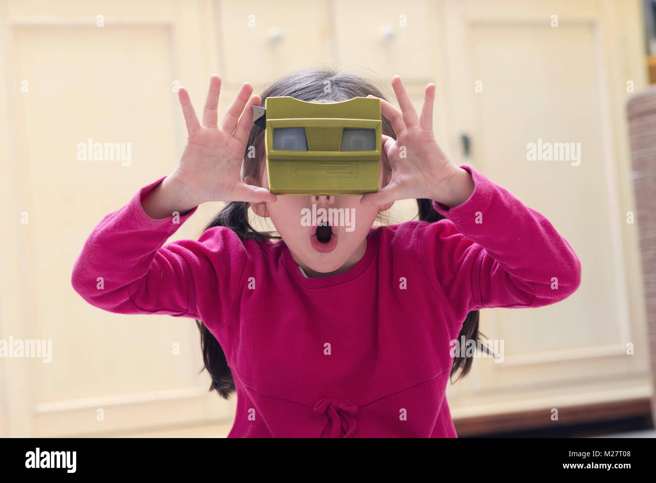 Kleines Mädchen spielt mit einer alten 3D-Viewer Stockfoto