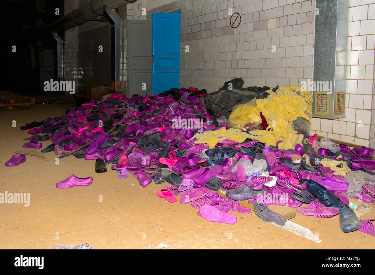 Die Entstehung von Abfällen. Alten, verlassenen Gummi mehrfarbige Hausschuhe im zerstörten Gebäude. Die Struktur der Zeit in der UDSSR. Zerstörung und Vandalismus. Stockfoto