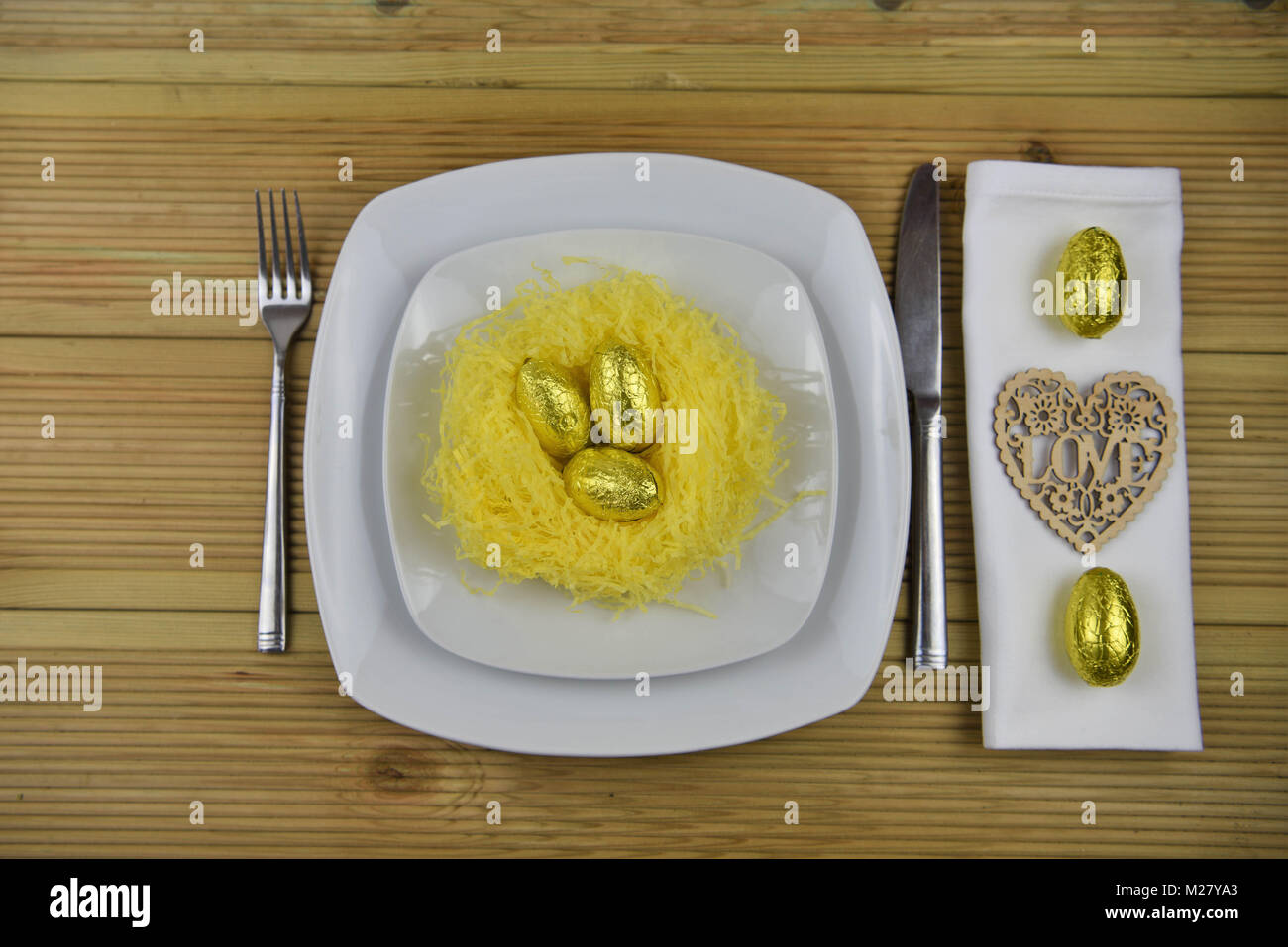 Ostern Tisch Einstellung mit Verzierungen aus einem Nest und Schokolade Ostereier Stockfoto