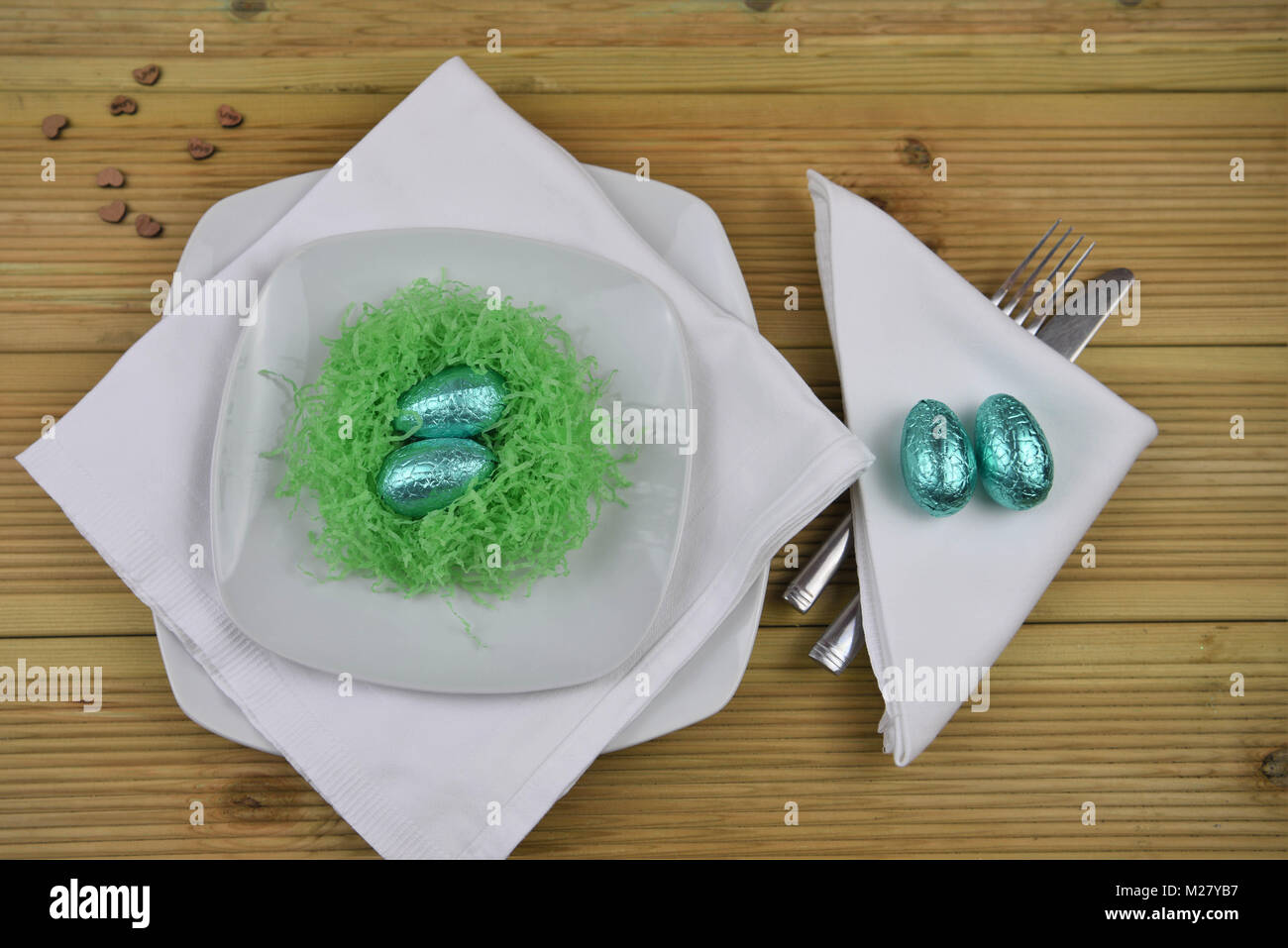 Ostern Tisch Einstellung mit Verzierungen aus einem Nest und Schokolade Ostereier Stockfoto