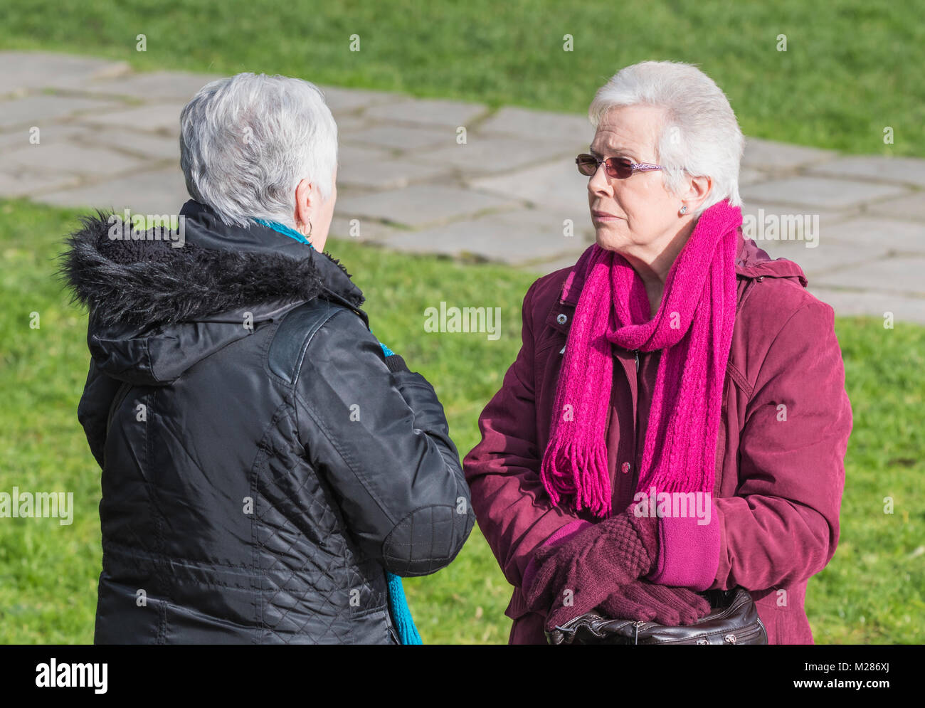 Paar ältere Frauen außerhalb sprechen miteinander, in Großbritannien. Stockfoto