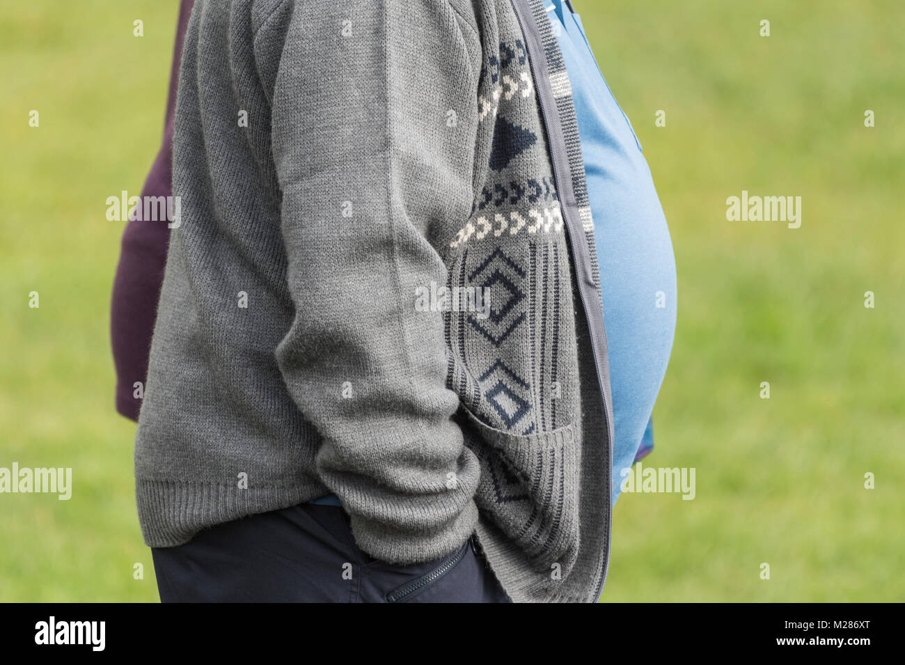 Profil der Verschwendung von einer großen Übergewichtigen übergewichtiger Mann mit einem großen Bauch heraus haften, in Großbritannien. Stockfoto