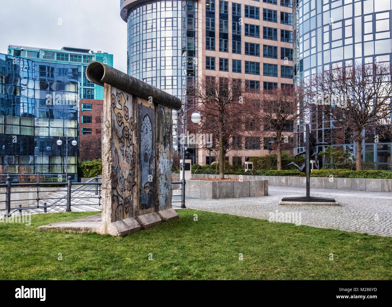 Berlin, Mitte, Moabit. Berliner Mauer Stück & Bronze Skulptur von Menschen durch die Wand von Rolf Bibi - Symbol der Fall der Berliner Mauer Stockfoto
