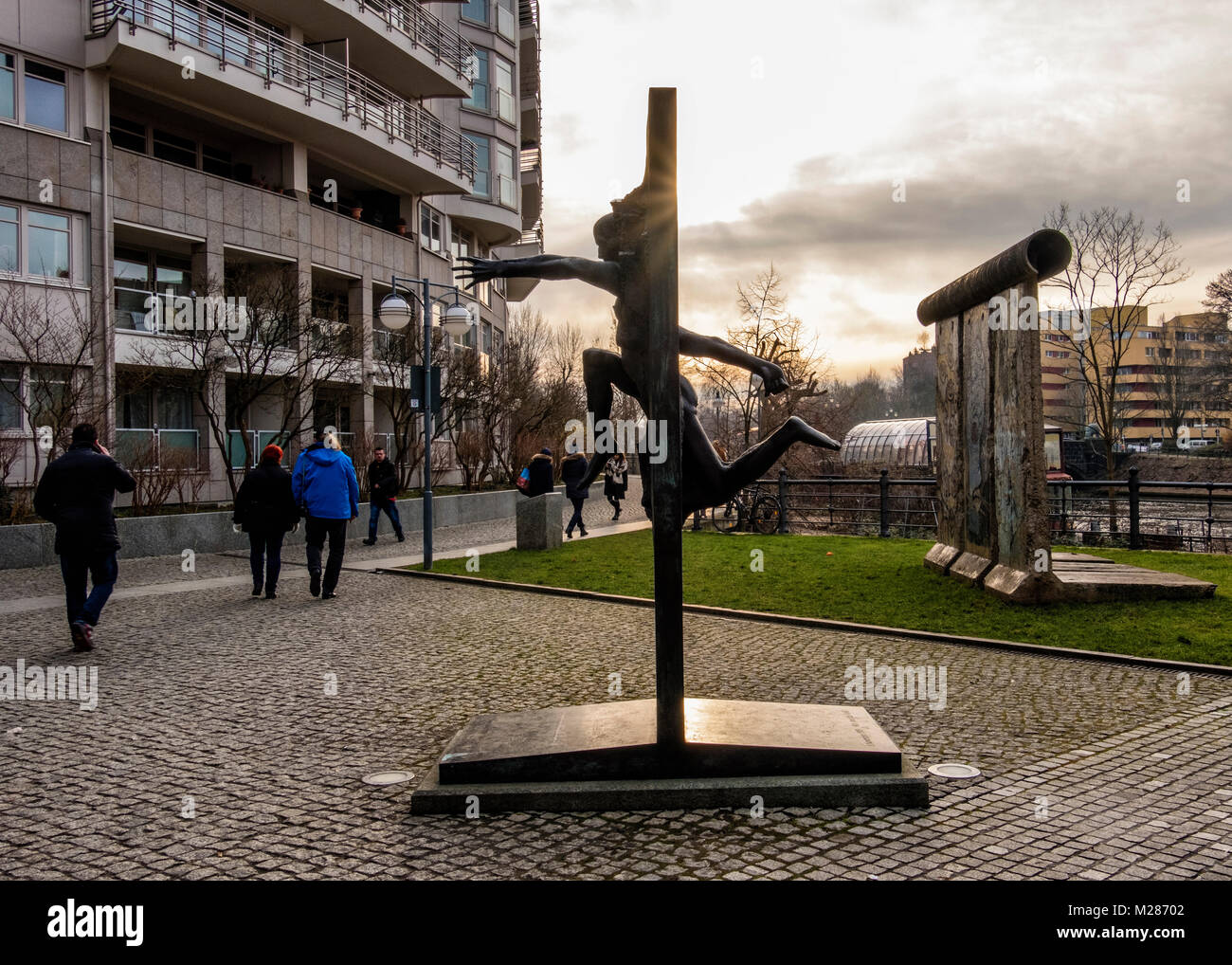 Berlin, Mitte, Moabit. Berliner Mauer Stück & Bronze Skulptur von Menschen durch die Wand von Rolf Bibi - Symbol der Fall der Berliner Mauer Stockfoto