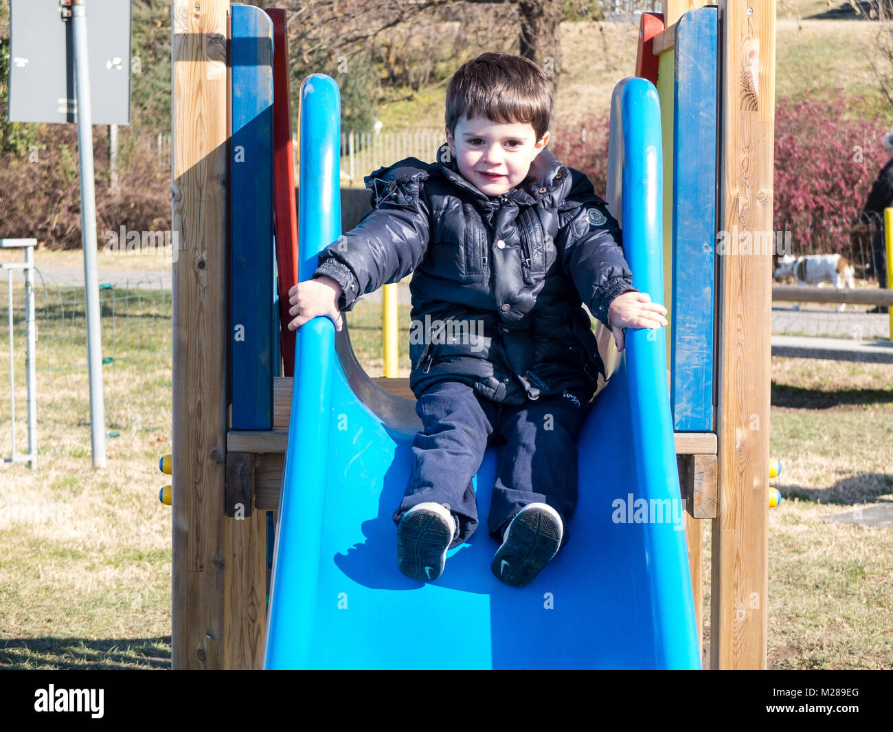 Portrait von 4 Jahre alten Kind beim Spielen auf dem Spielplatz schieben Stockfoto
