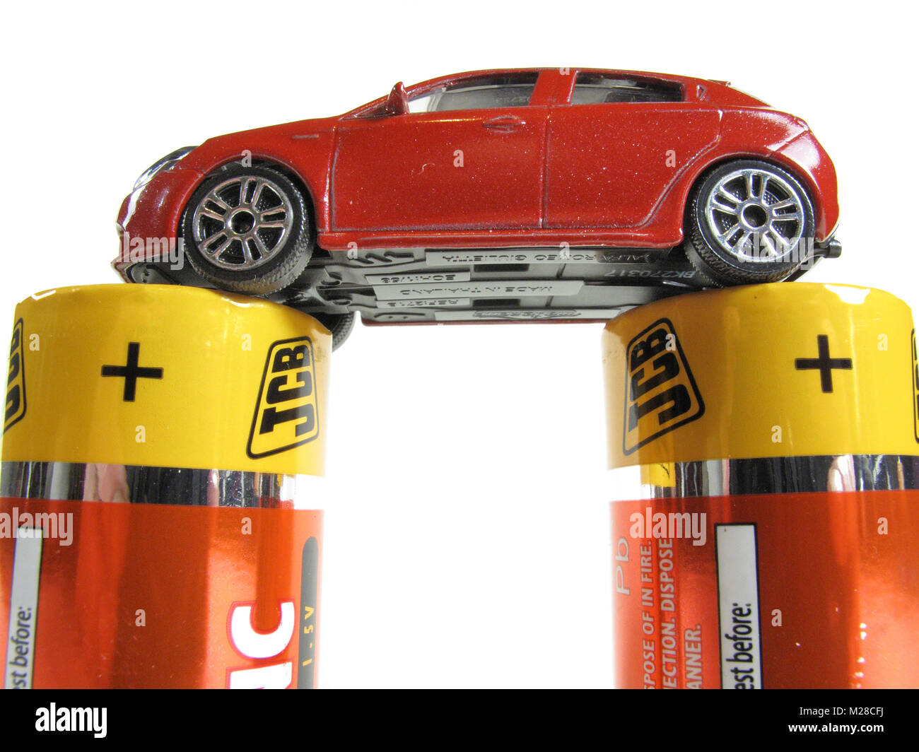 Ein Spielzeug Alfa Romeo Giulietta rotes Auto sitzt auf 2 große Akkus Stockfoto