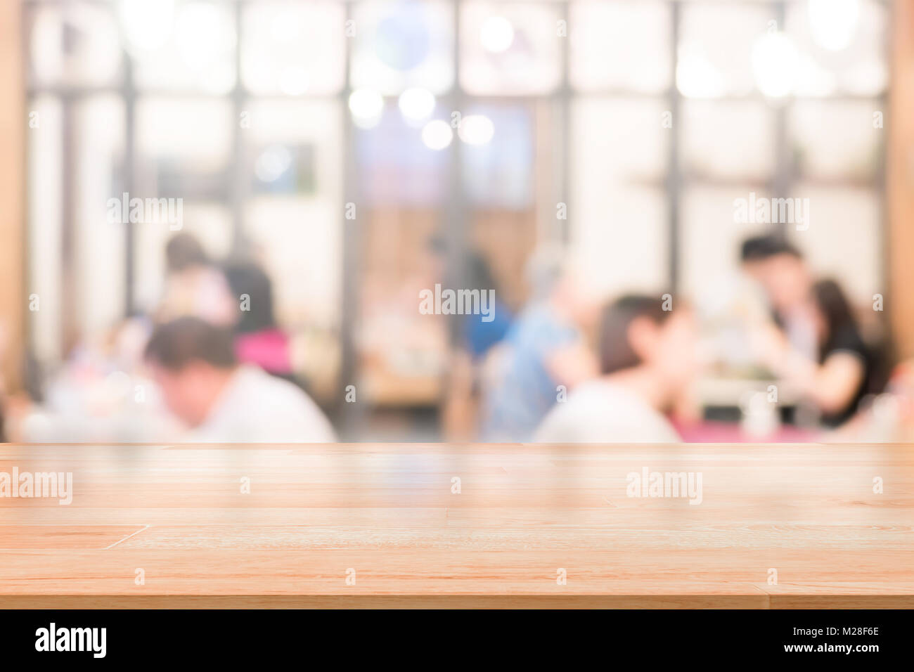 Leere Holz Tischplatte mit Kunden im Restaurant blur Hintergrund mit Bokeh oder Kaffee Cafe Hintergrund für Montage Produkt vorhanden Stockfoto