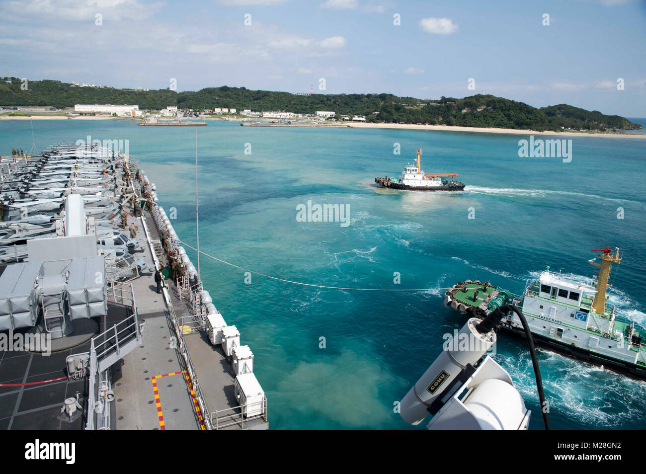 WHITE BEACH, Okinawa (Feb. 2, 2018) eine Tug Boat führt den Amphibious Assault ship USS BONHOMME RICHARD (LHD 6) weg vom Pier während des Schiffes Abfahrt vom Weißen Strand Marinestützpunkt, Okinawa. Bonhomme Richard ist in den Indo-Asia-Pazifik-Region als Teil einer regelmäßigen Patrouillen- und bietet eine schnelle Reaktionsfähigkeit im Falle eines regionalen Kontingenz oder Naturkatastrophen. (U.S. Marine Stockfoto