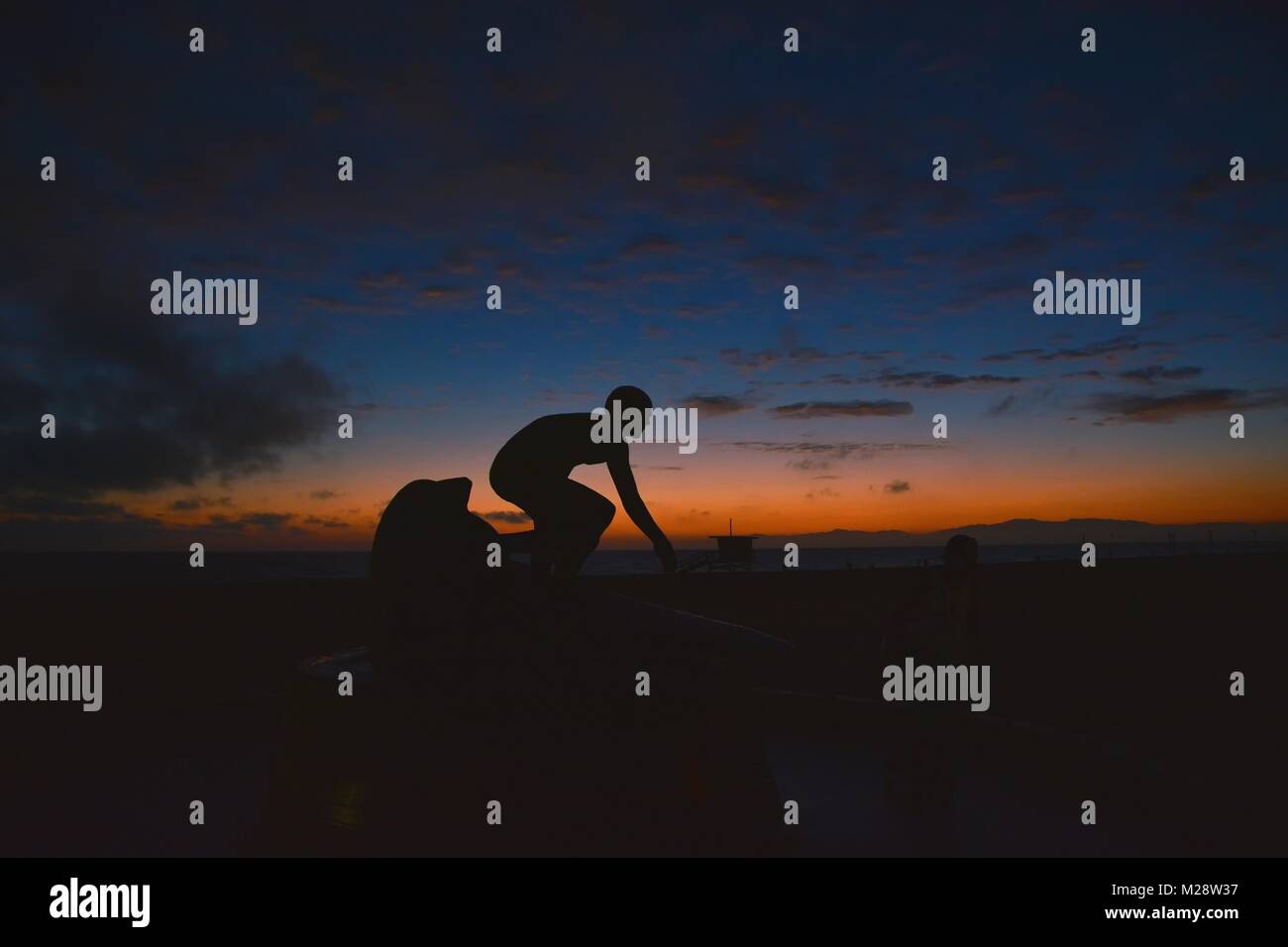 Surfen bei Sonnenuntergang. Junger Mann auf Welle bei Sonnenuntergang. Outdoor-aktiven Lebensstil. Stockfoto