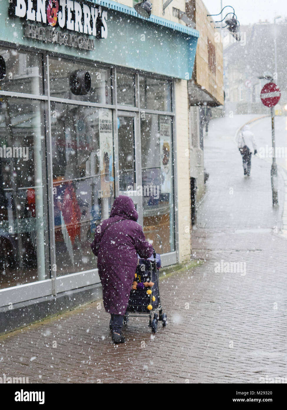 Newquay, Cornwall, England. 6. Februar, 2018. Ungewöhnlich schweren Schnee fällt an der Nordküste von Cornwall. In der Stadt Menschen durch die schweren Schneefälle gehen. Credit: Nicholas Burningham/Alamy leben Nachrichten Stockfoto