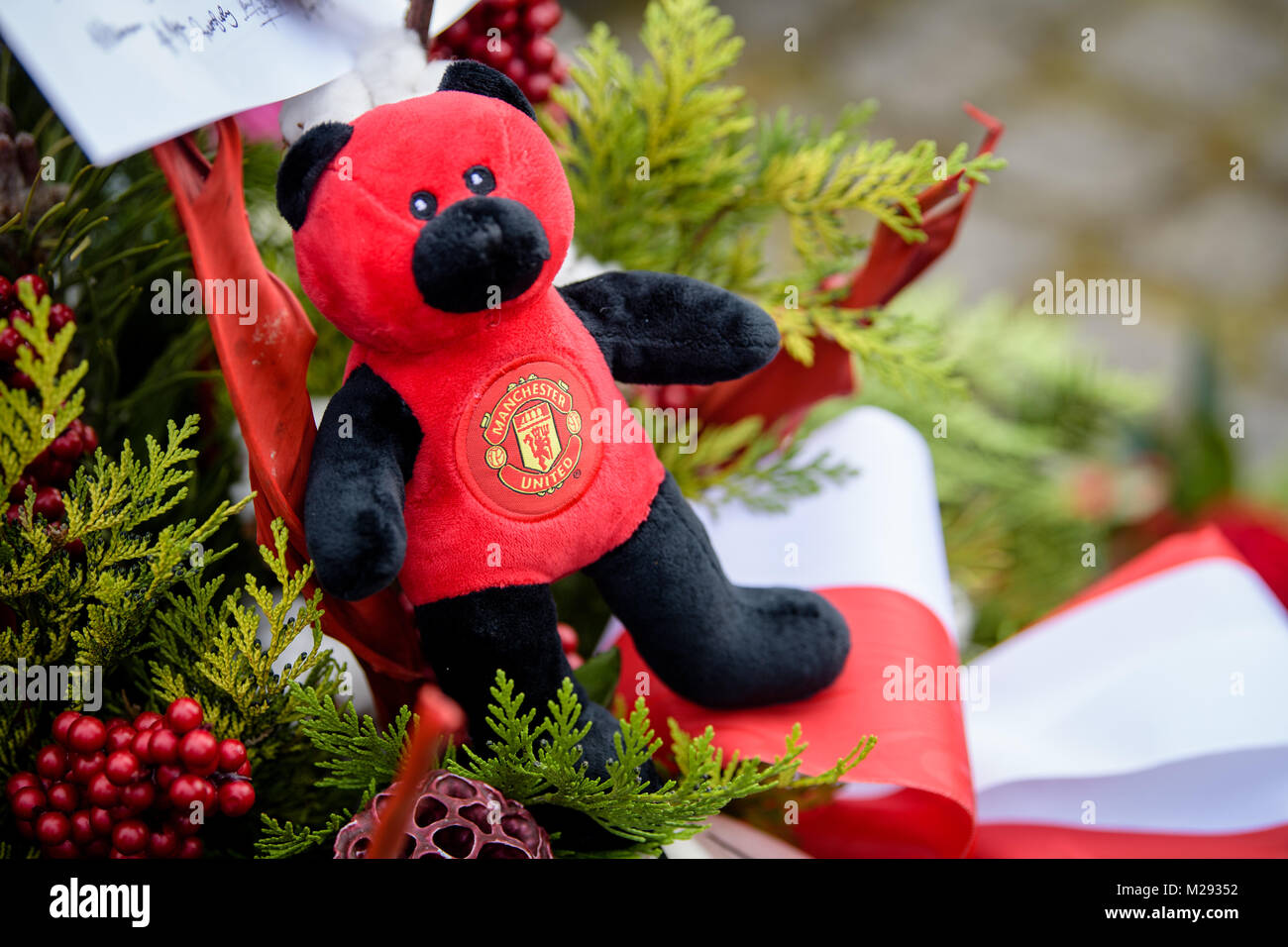 München, Deutschland. 06 Feb, 2018. Ein Bär mit dem Team Logo während einer Gedenkveranstaltung für die Opfer des Flugzeugabsturzes von Manchester United am Manchester Square in Riem, München, Deutschland, 06. Februar 2018. Vor 60 Jahren ein Flugzeug mit professionellen Fußballspieler von Mancester United stürzte an diesem Ort. Credit: Matthias Balk/dpa/Alamy leben Nachrichten Stockfoto