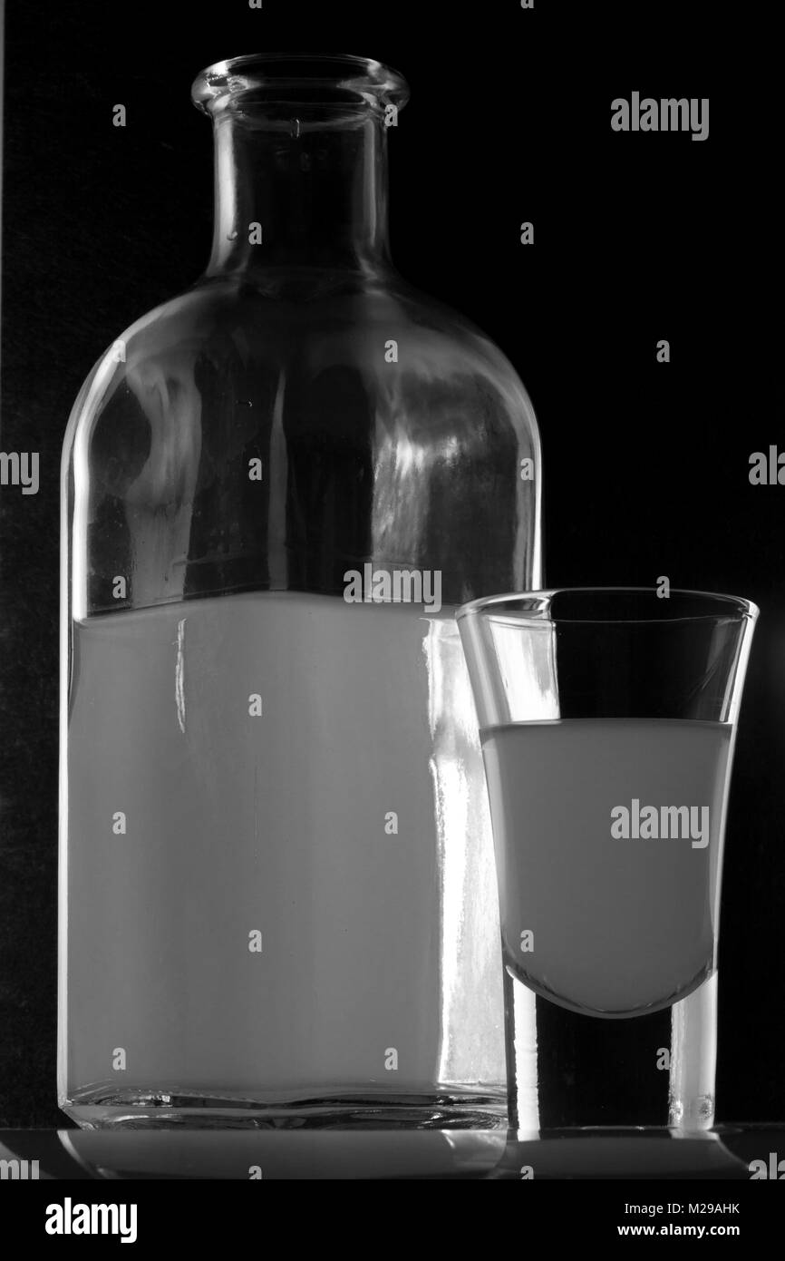 Bank von MOONSHINE und ein Glas auf schwarzem Hintergrund Stockfoto