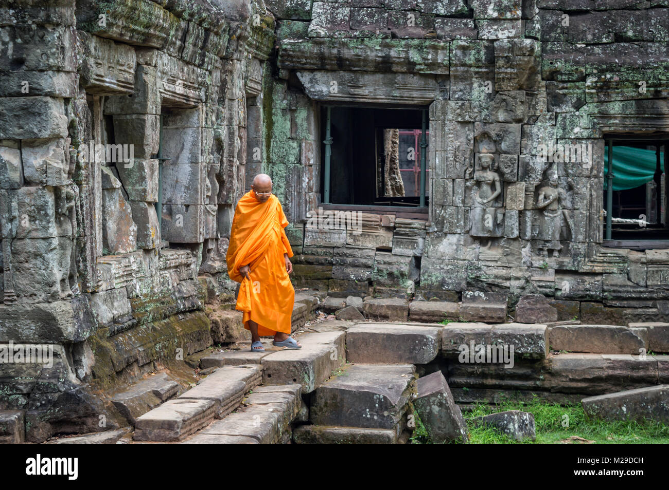 Mönch in orange Robe in einen alten Tempel in Angkor Wat, Kambodscha, Siem Rep Stockfoto