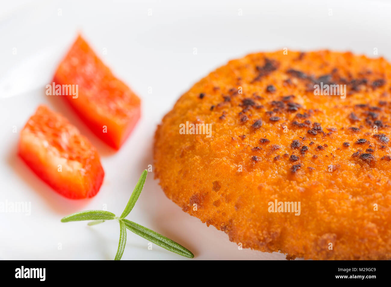 Nahaufnahme von Hähnchen Cordon Bleu auf Platte mit Rosmarin und rotem Pfeffer Stockfoto