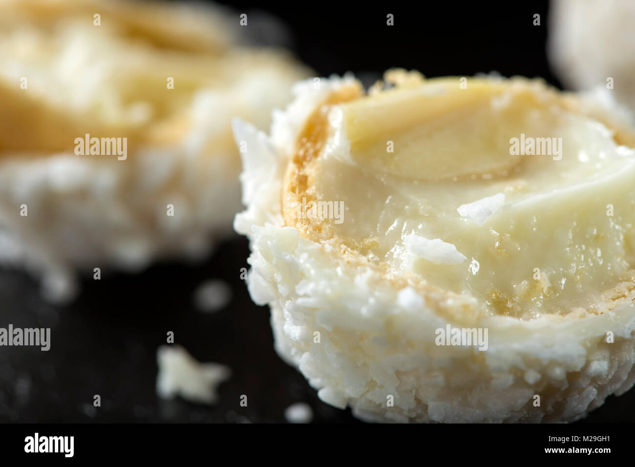 In der Nähe von Broken Raffaello weiße Süßigkeit mit Kokosraspeln auf einer Schiefertafel dunklen Hintergrund Stockfoto