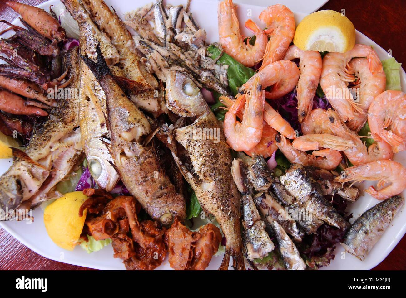 Griechische Küche - Traditionelle gegrillte Meeresfrüchte Teller mit Krabben, Sardellen, Sardinen, Tintenfisch und andere Fische. Stockfoto