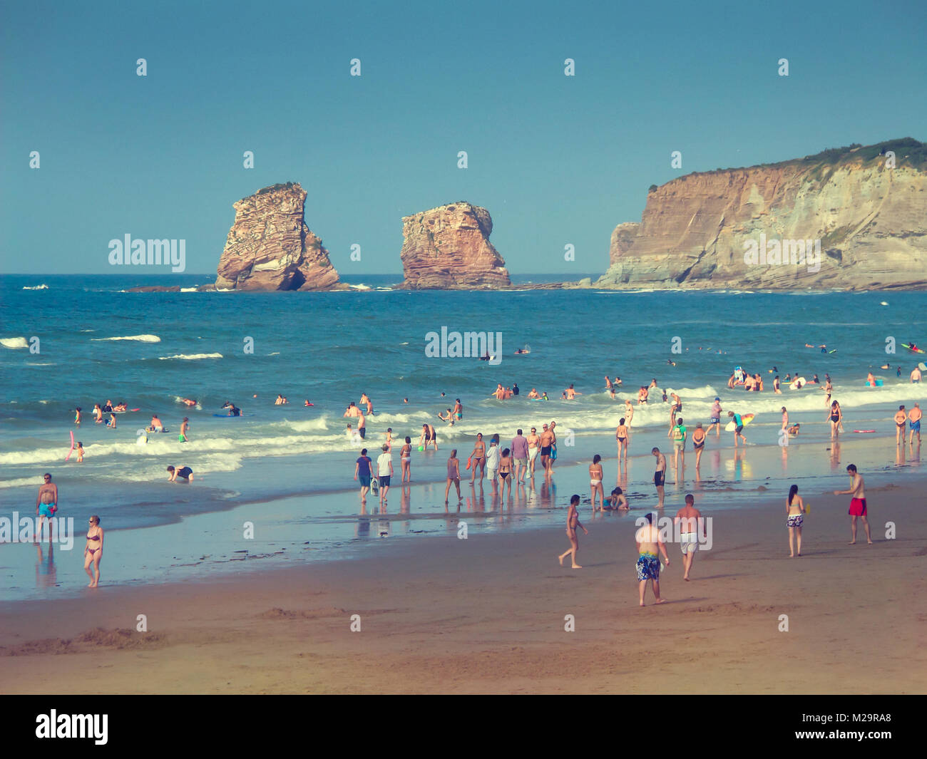 Menschen auf Hendaye Strand in Frankreich, die Zwillinge Felsen im Hintergrund Stockfoto