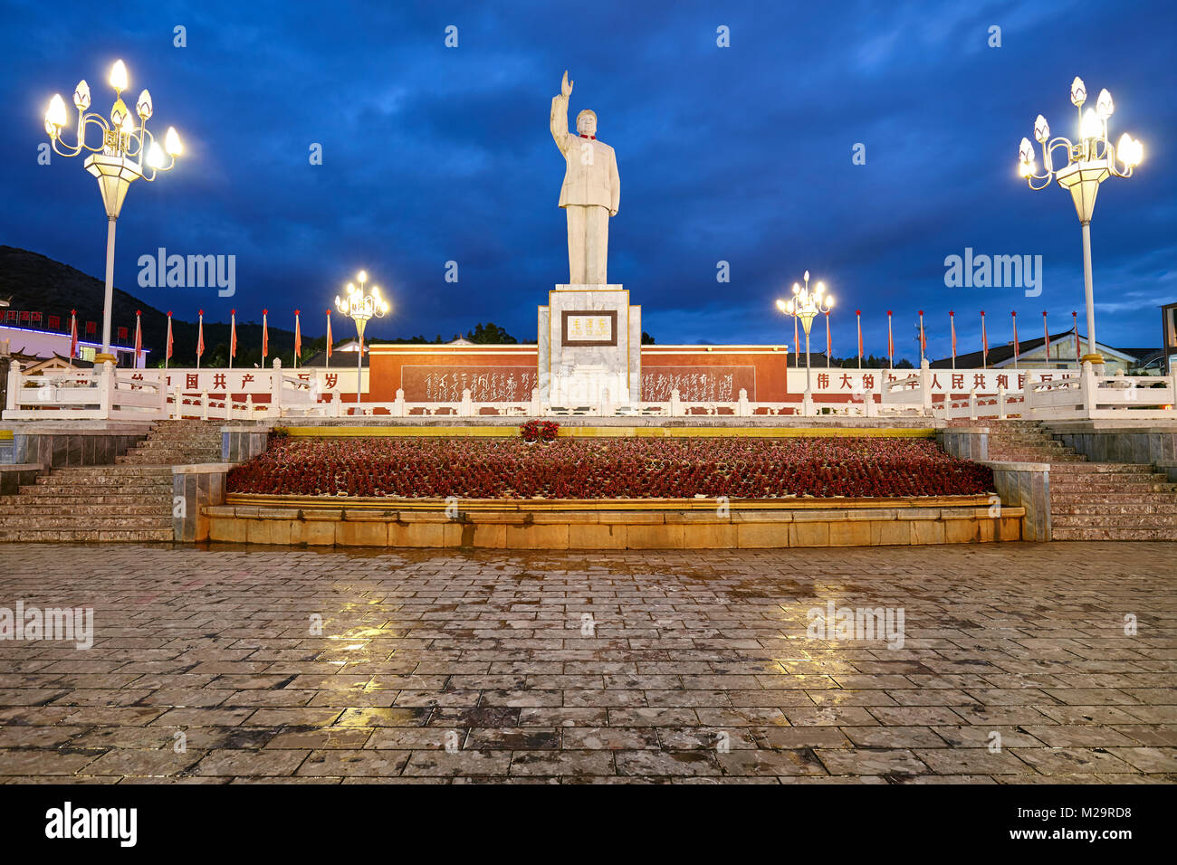 Lijiang, China - 22. September 2017: Mao Tse Tung Statue in der roten Sonne Quadrat in der Nacht. Stockfoto