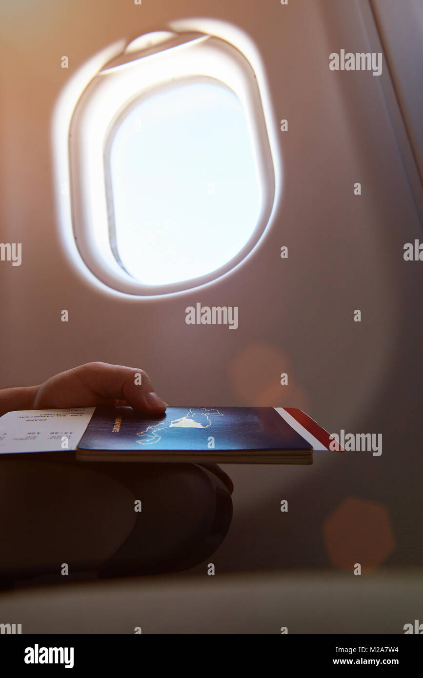 Nahaufnahme einer Hand, die Pass neben Flugzeug Fenster reinigen Stockfoto