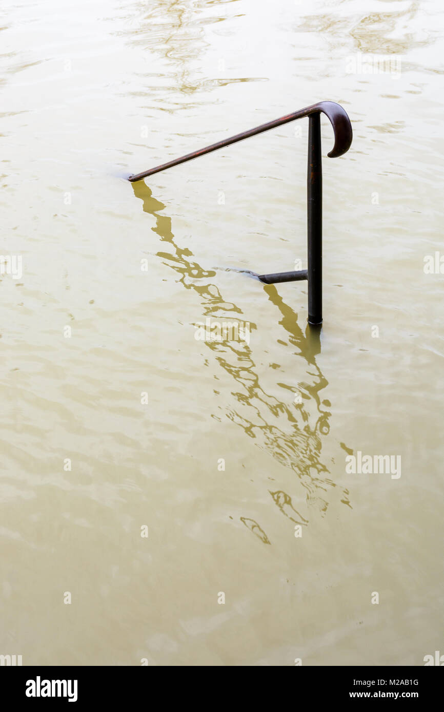 Der obere Teil von einem schmiedeeisernen Geländer klemmt aus dem schlammigen Fluten des geschwollenen Seine während eines Winters Flut Episode in Paris im Janu Stockfoto