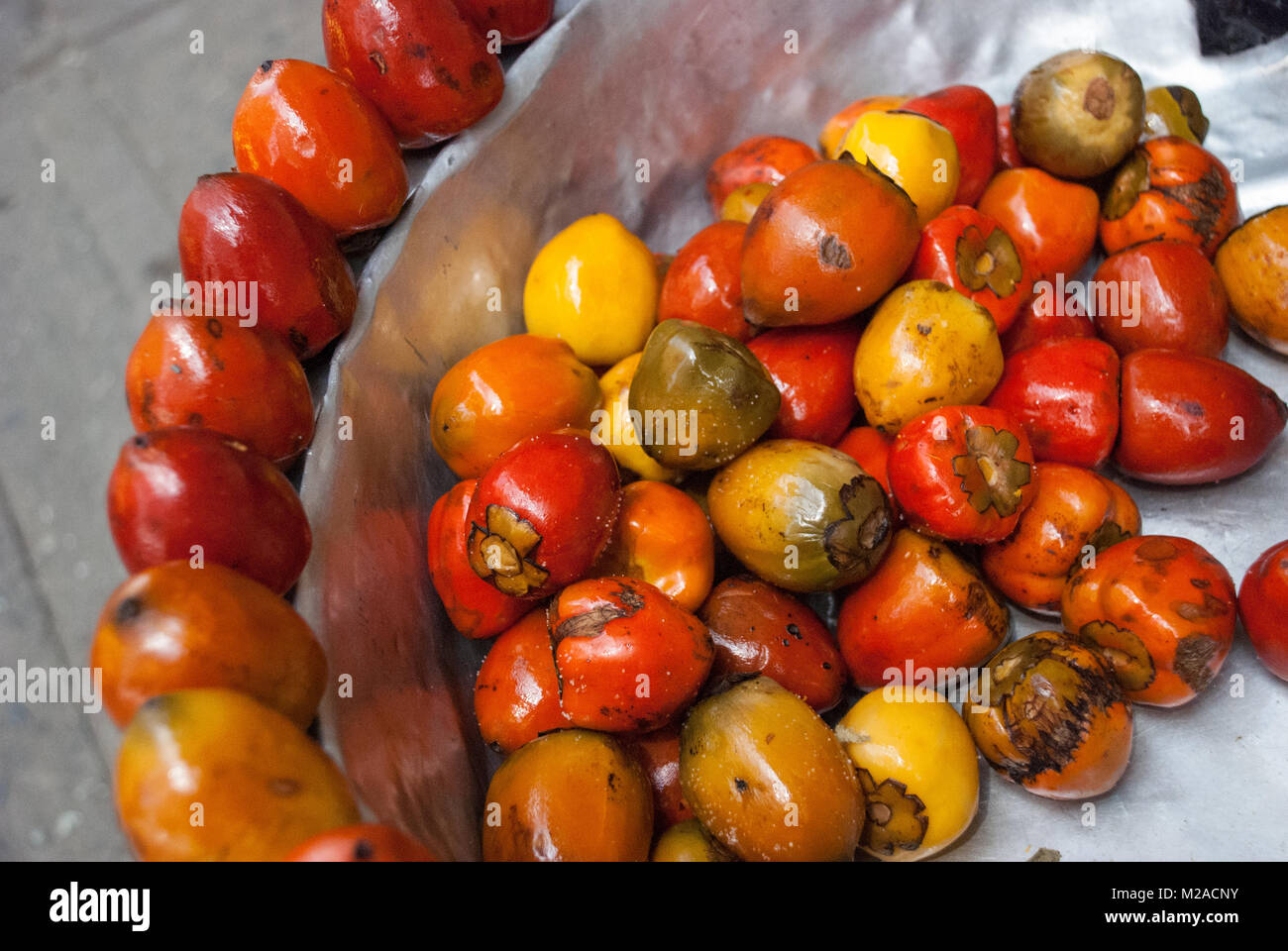 Bunte chontaduro Obst auf Verkauf in einer Metallschüssel in Cali, Kolumbien Stockfoto