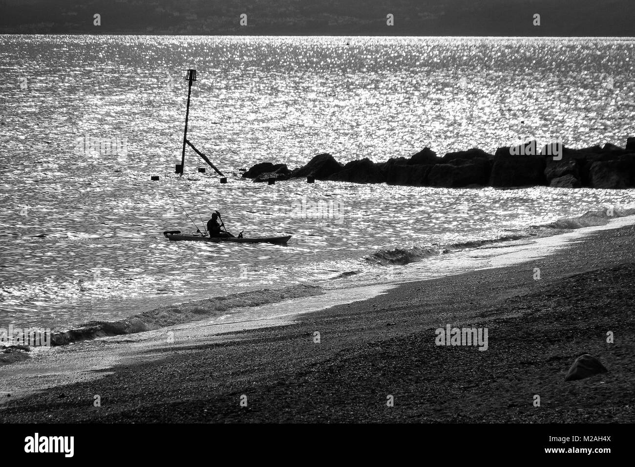 Fischer in einem Kajak, an der West Bay, Dorset UK. Shot in Schwarz & Weiß. Stockfoto