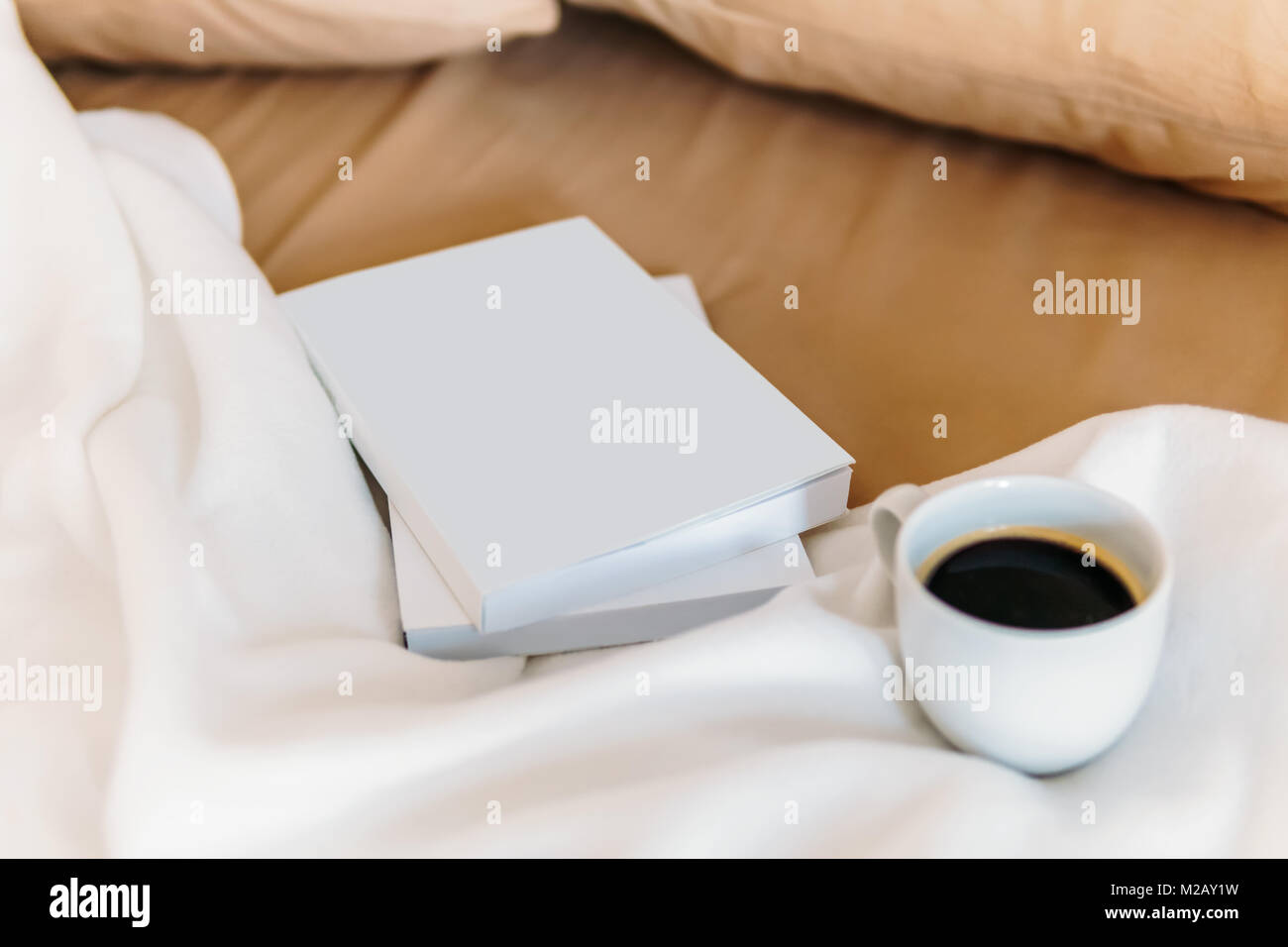 Entspannen mit Kaffeetasse und gute Bücher im Bett am Wochenende Stockfoto