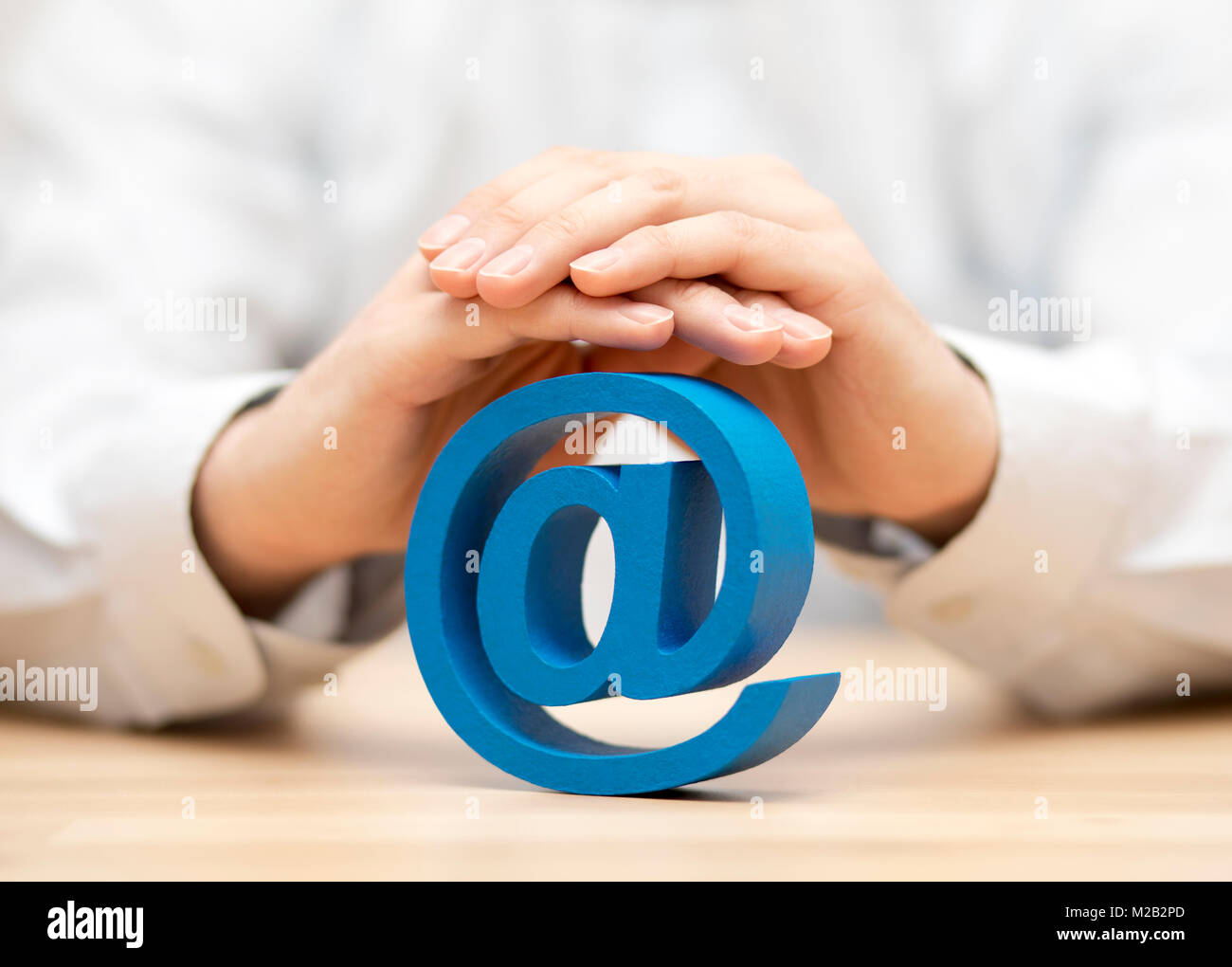 Blue e-Symbol, das durch die Hände geschützt Stockfoto