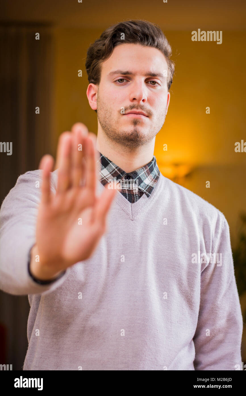 Stattlich, seerious junger Mann, STOP-Schild mit Hand Stockfoto