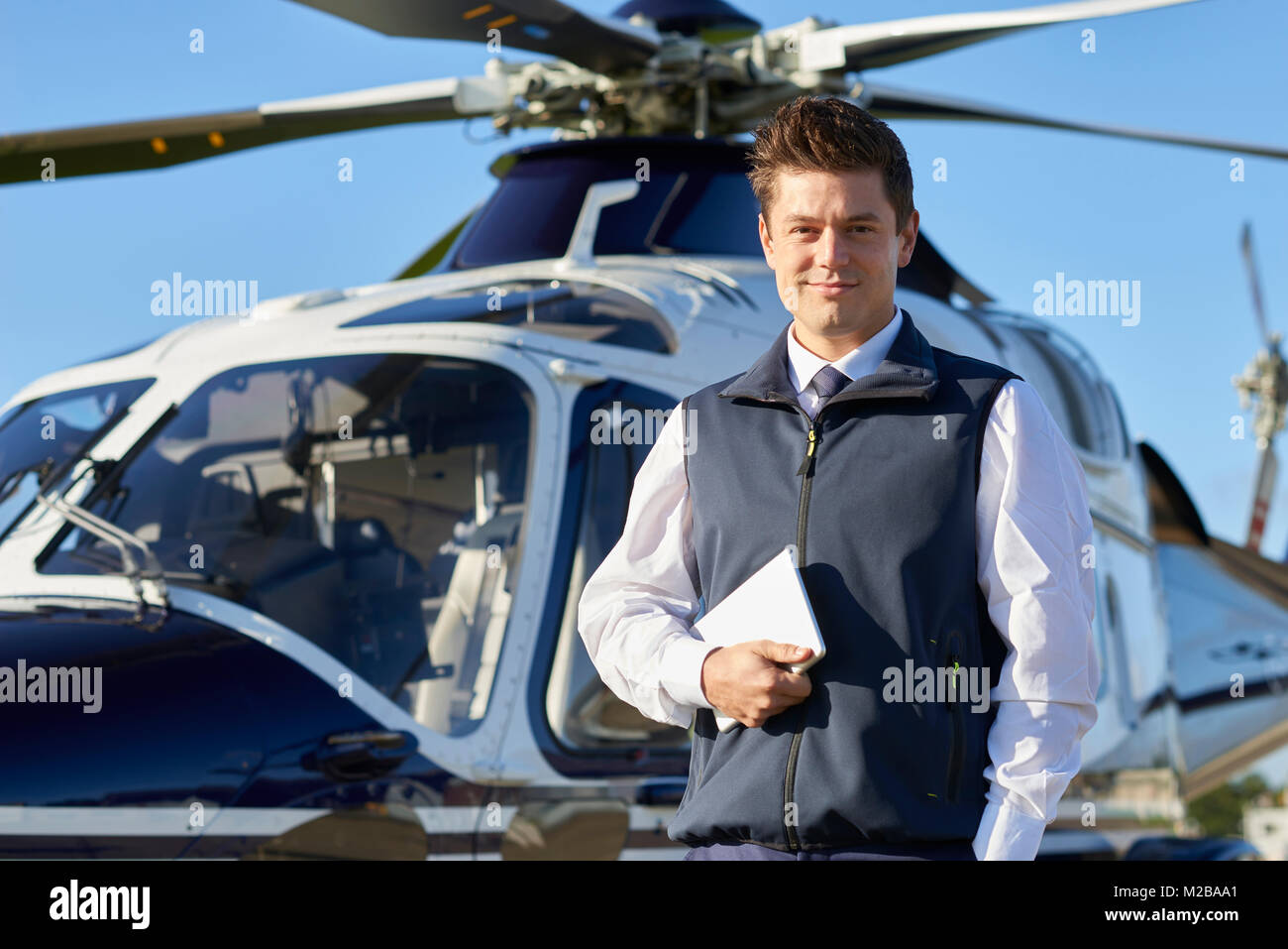 Portrait von Pilot Stand vor der Helikopter mit digitalen Tablet Stockfoto