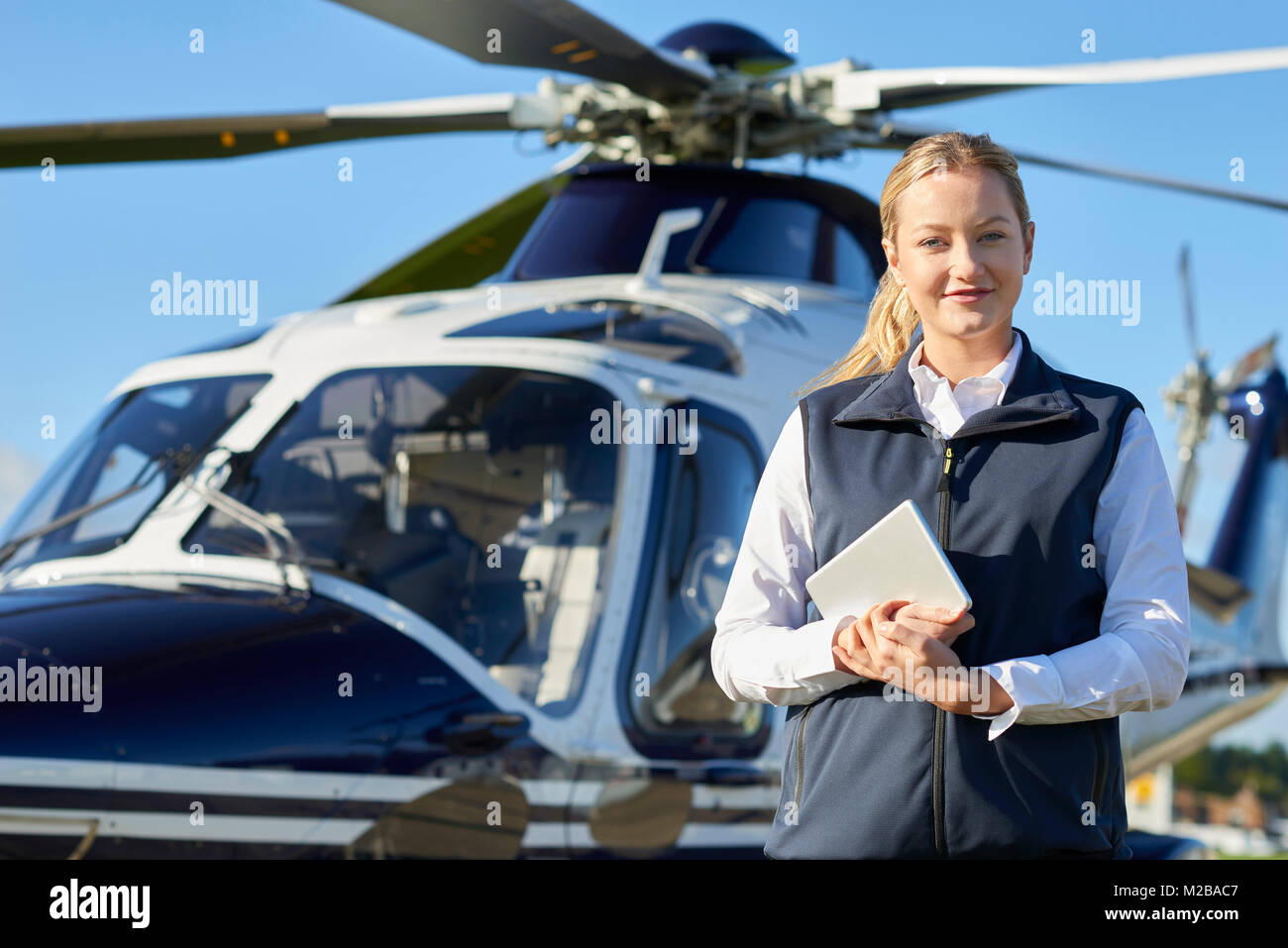 Portrait von Pilotin Stand vor der Helikopter mit digitalen Tablet Stockfoto